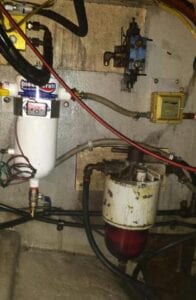 A dirty wall with wires and an air compressor.